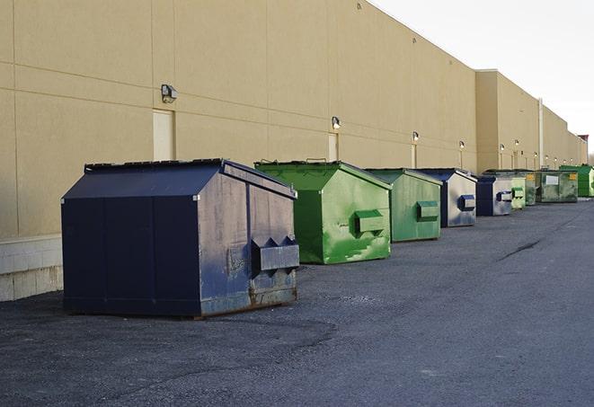 a pile of demolition waste sits beside a dumpster in a parking lot in Clay City